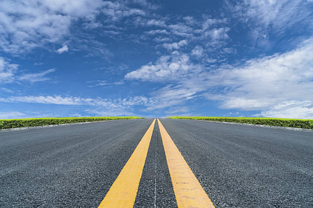 road ahead empty asphalt road to horizon under cloudy sky. vanishing point photos stock pictures, royalty-free photos & images