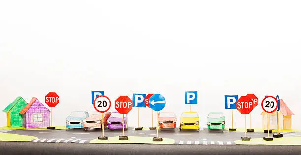 Picture of playing set of road signs and paper cars in a parking maquette with copy-space