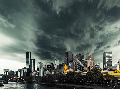 Severe summer storm looms over Melbourne city and iconic Flinders Street Station. Horizontal, copy space, multiple logos, contentious signs removed, dramatic processing,