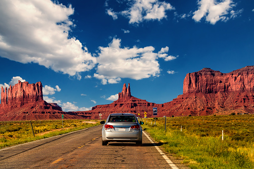 Monument Valley, United States - September 10, 2015: Highway in Monument Valley, Utah / Arizona, USA - Picture with road and cars driving towards the hills. Photo made during a road trip throughout the western states.