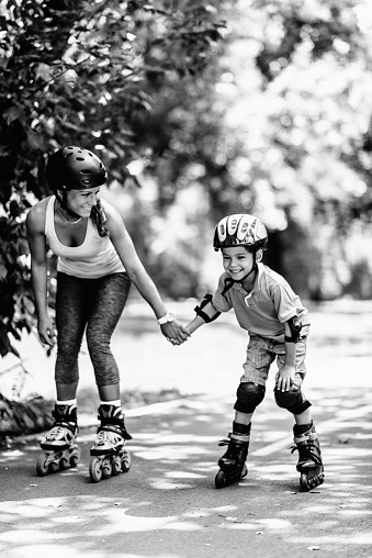Portrait of a young woman on skates smiling at camera in the park. Concept of sport