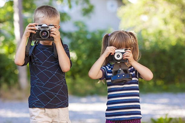 istock Little boy and girl learning how to use photo camera 636865344