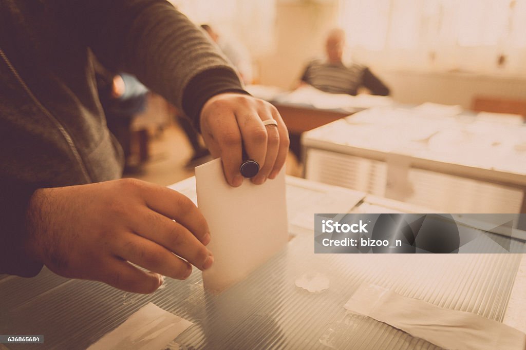 Person voting at polling station A person casts her ballot during voting for parliamentary elections at a polling station in Bucharest, Romania. Voting Stock Photo