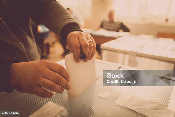 Person Voting At Polling Station Stock Photo - Download Image Now - Voting, Voting Ballot, Democracy