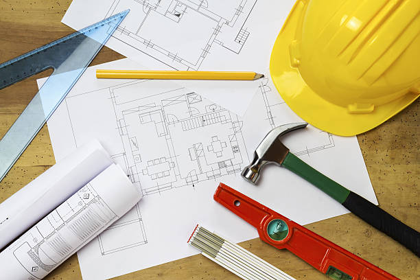 istock Protective helmet, mason tools and project drawings on wood background 636866106
