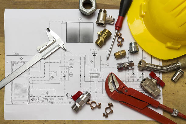 istock Office desk with hydraulic fittings, helmet  and project design 636866280