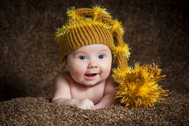 istock Newborn in knitted winter hat on a beige background. 636869460