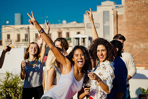 istock Happy friends drinking wine at rooftop party 636869582