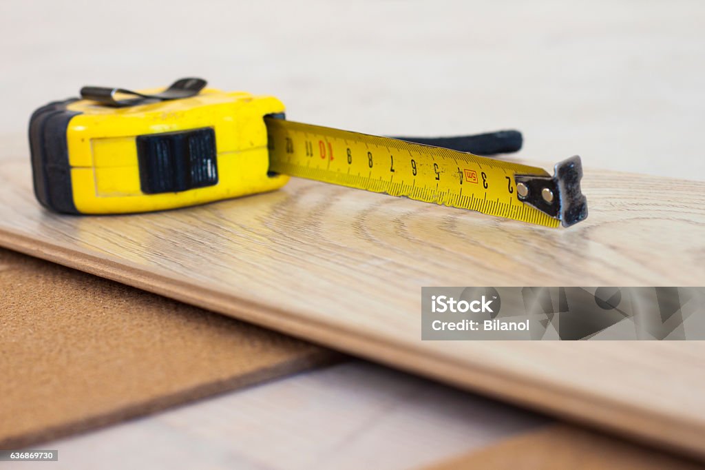 Measuring tape on laminate floor plank Apartment Stock Photo