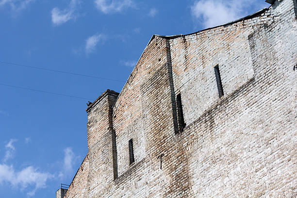 façade de l’ancien bâtiment avec fenêtres, sur ciel bleu - warehouse store retail shopping photos et images de collection