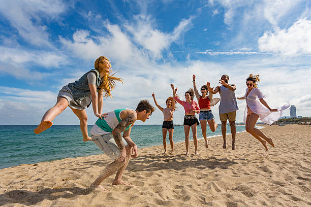 istock Couple Playing Leapfrog on the Beach With Friends 636871326