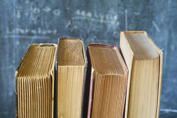 istock row of old books, blackboard background 636872148