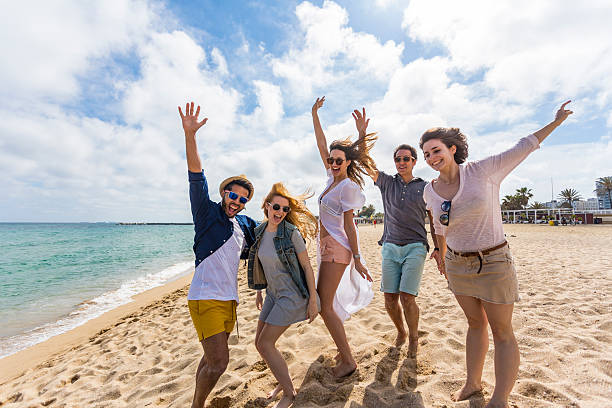 istock Group of Friends Having Fun Messing Around on the Beach 636874084
