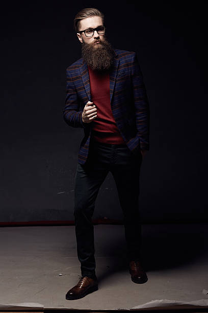 istock Handsome fashionable man with beard in dark studio 636874364