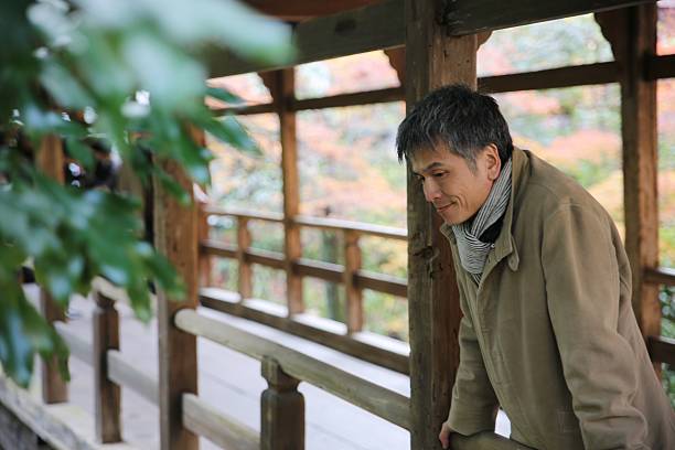 istock Maletraveller bending on the brigde at autumn temple 636874602