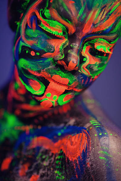 istock Portrait painted with fluorescent makeup under the ultraviolet l 636877010