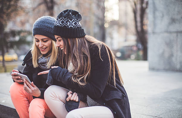 istock Two women with phone in the park 636880812