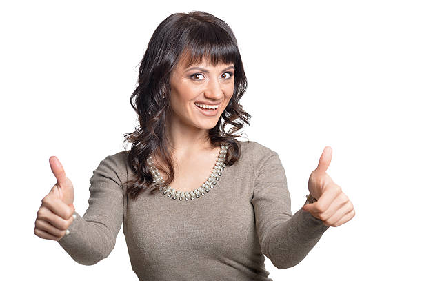 Woman shows thumbs up Portrait of happy young woman shows thumbs up isolated on white background sighing stock pictures, royalty-free photos & images