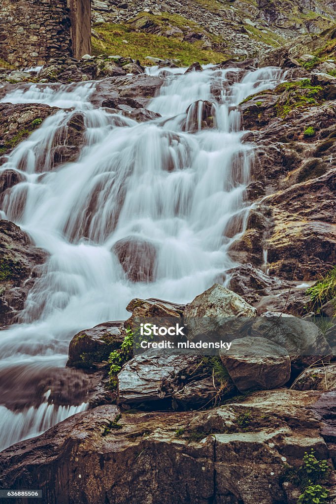 Majestic mountain stream waterfall Majestic mountain stream waterfall nearby the famous Transfagarasan road in Fagaras mountains, Romania. Long exposure motion blur. Awe Stock Photo