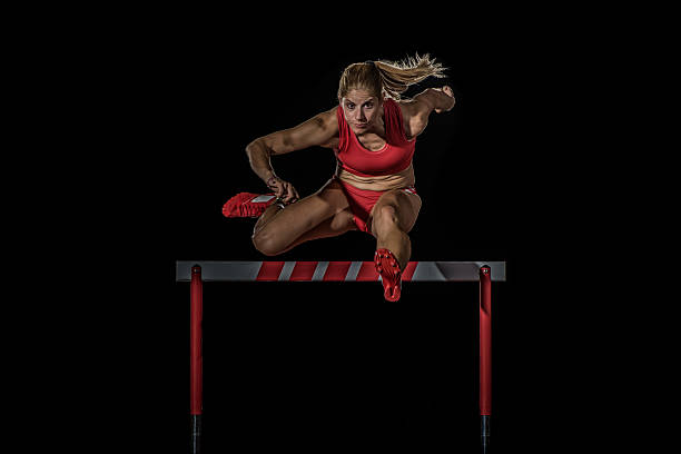 athlete clearing hurdle - hurdling hurdle running track event imagens e fotografias de stock