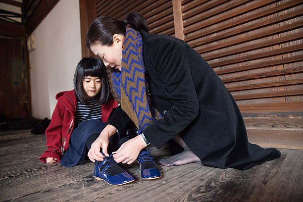 istock Mother helps doing up her daughter's shoelaces 636886636