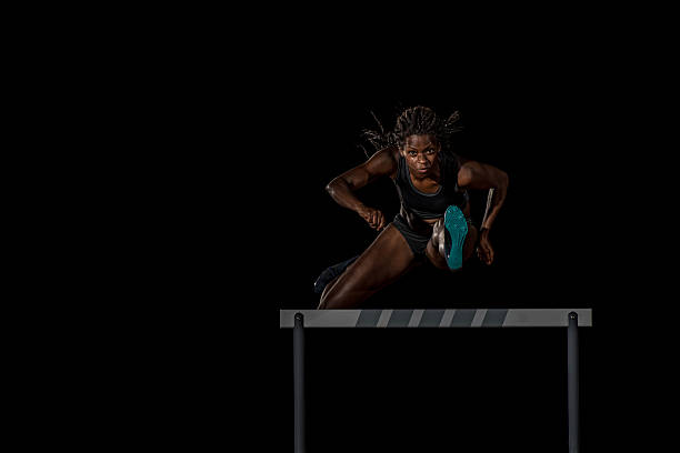 athlete clearing hurdle - hurdling hurdle running track event imagens e fotografias de stock