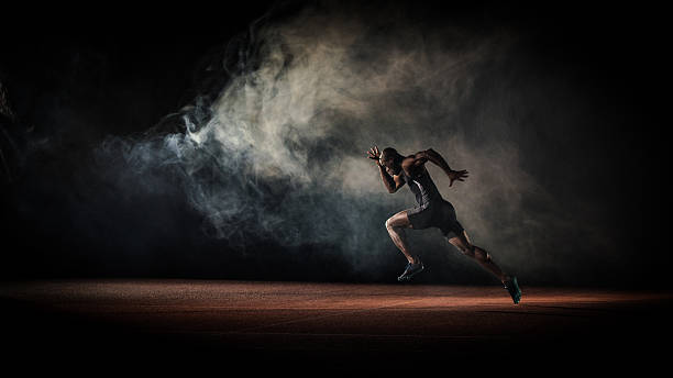 Athlete running Young male athlete running on race track. muscular build stock pictures, royalty-free photos & images