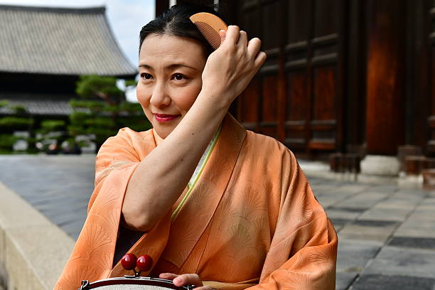 femme japonaise en kimono peignant ses cheveux à tofuku-ji, kyoto - obi sash photos et images de collection