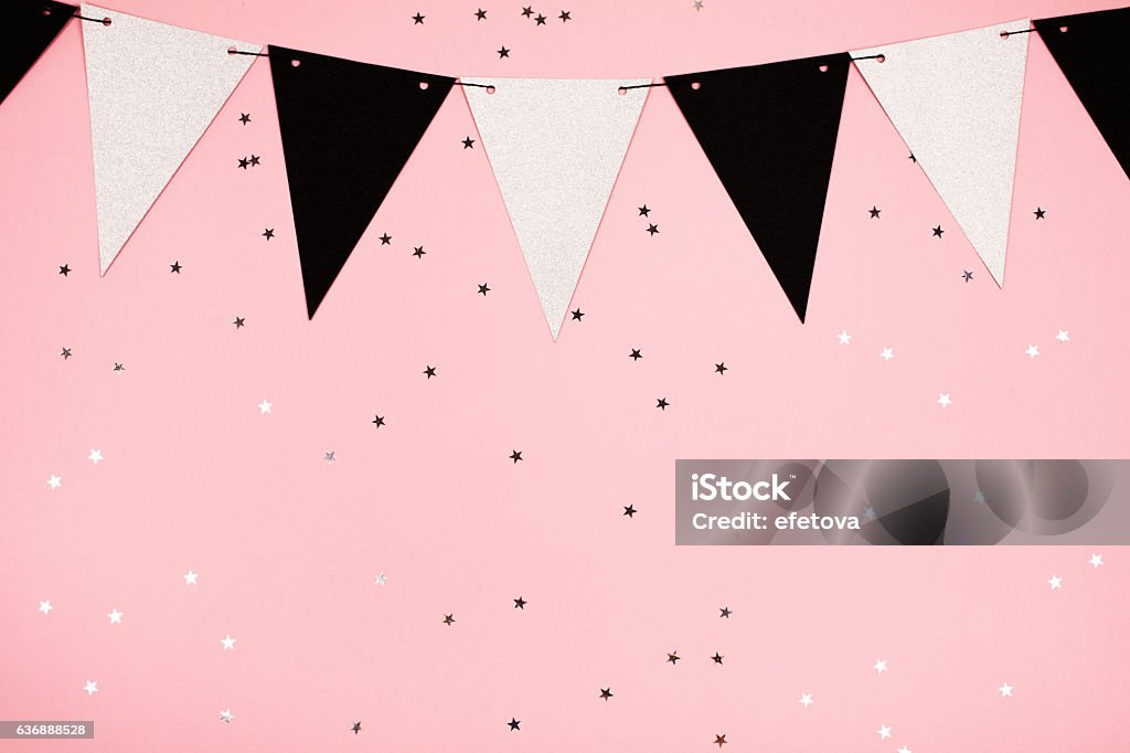 Festive pink background, flat lay Festive background made of decorative flags and little stars, flat lay. Pink trend background with little silver stars on it. Flat lay style. Confetti Stock Photo