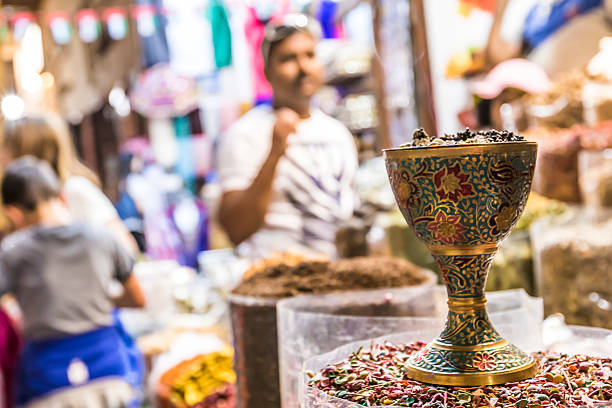 Dubai, United Arab Emirates - December 26, 2016: Incense burner on the sack of spice, these incense burners burn an aromatic substance called bakhoor to perfume the local stores. A traditional old market in Deira, this gem of Old Dubai remains far from the likes of the iconic landmarks, such as Burj Al Arab or Burj Khalifa; this souq modestly remains in the place where it all began for Dubai. Upon entry, no one can resist taking a deep breath as they take their first steps down the snaking alleys that weave around the buildings near Baniyas Street; taking in the Arabic incense, authentic Iranian Spices, & automatic herbs from the Middle East. While known as the “Spice” Souq, the tourists that find their way here can also find troves of Arabian textiles, rugs, artifacts, and souvenirs to take home.  