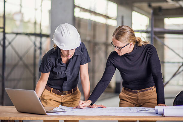 istock Two female architects reviewing blueprints 636889740