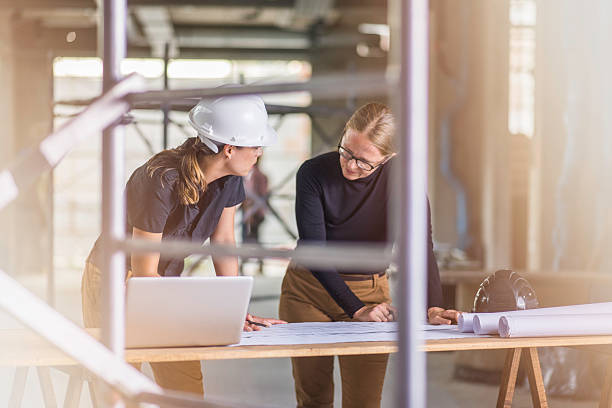 istock Two female architects reviewing blueprints 636889794