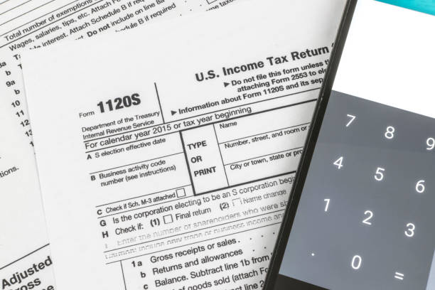 IRS Form 1120S Small Corporation Income Tax Return Close up shot of United States Internal Revenue Service (IRS) tax return form 1120S for small business also known as S-Corps next to a calculator. section 125 tax stock pictures, royalty-free photos  images