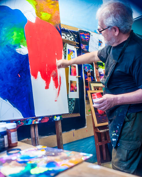 istock Elderly man with white hair, artist, painter, working.. 636897006