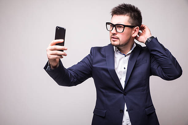 istock Young man in suit  looking at phone isolated white background 636897552