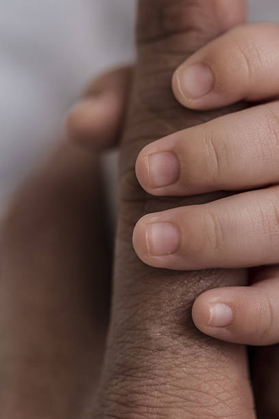 istock Baby hand holding father's finger 636897570