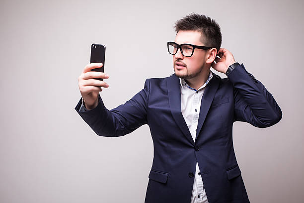 istock Young man in suit  looking at phone isolated white background 636897620