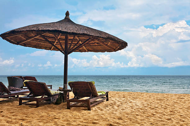 istock Wooden chairs and umbrellas on white sand beach 636906224