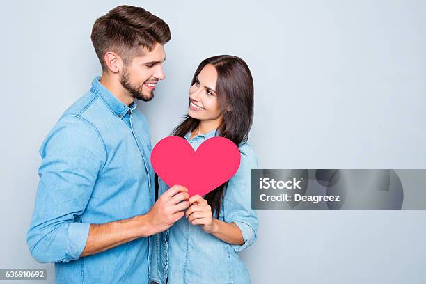 Two Lovers Holding Paper Heart On Gray Background Stock Photo - Download Image Now - Boyfriend, Couple - Relationship, Smiling