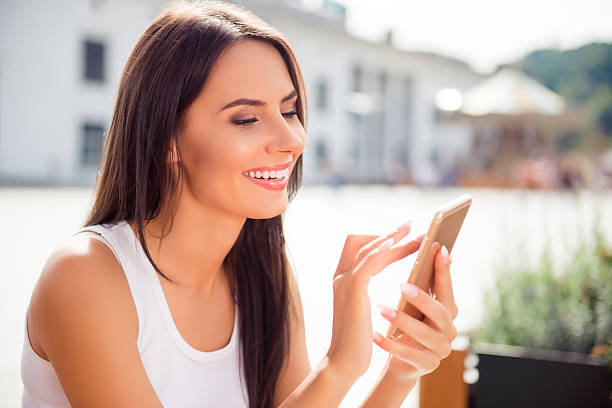 istock Attractive cheerful brunette woman having walk and typing sms 636911006