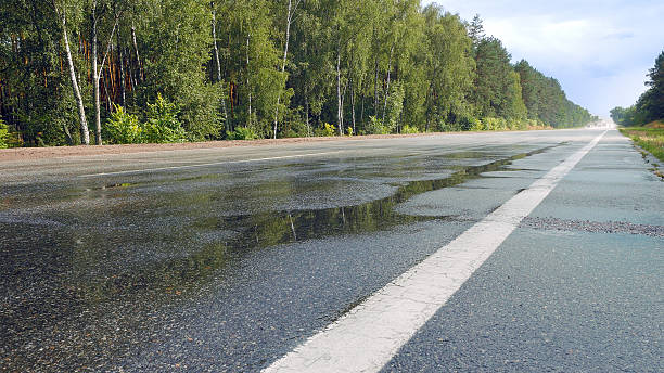 istock Wet road highway with mist splash 636911528