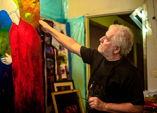 istock Elderly man with white hair, artist, painter, working.. 636913310