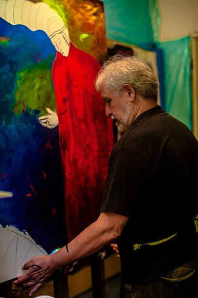 istock Elderly man with white hair, artist, painter, working.. 636913500