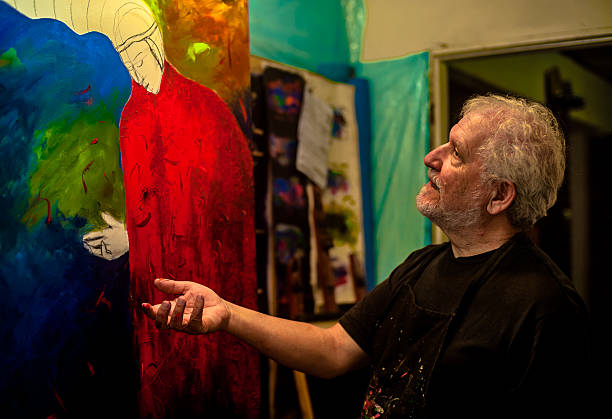 istock Elderly man with white hair, artist, painter, working.. 636913752