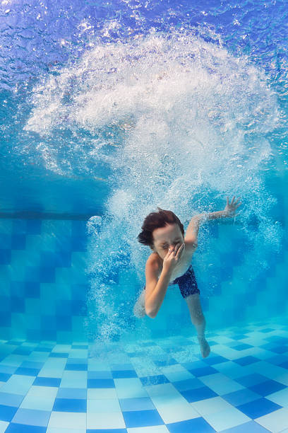 istock Child diving underwater in swimming pool 636915430