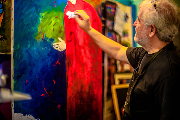 istock Elderly man with white hair, artist, painter, working.. 636915492