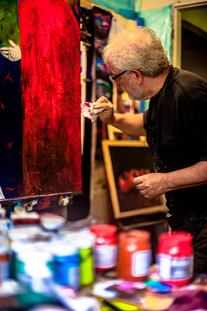 istock Elderly man with white hair, artist, painter, working.. 636915744