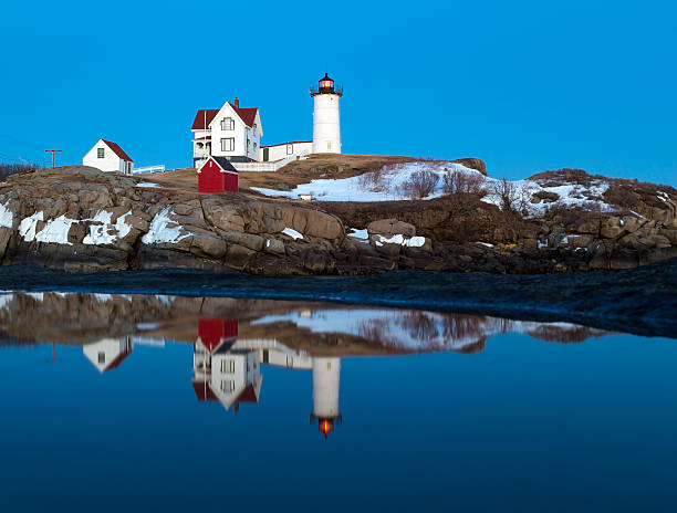 istock Nubble Light reflecting in puddle during Winter twilight 636916402
