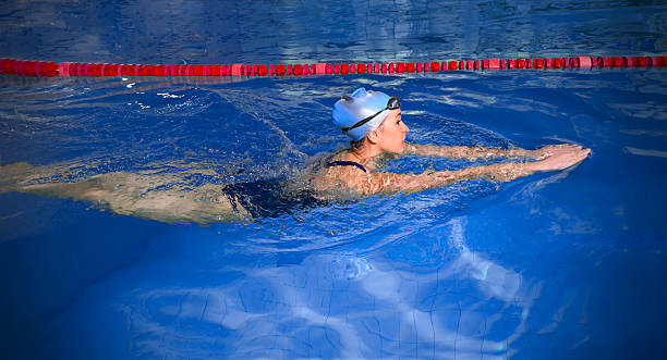 junge frau schwimmer - breaststroke stock-fotos und bilder