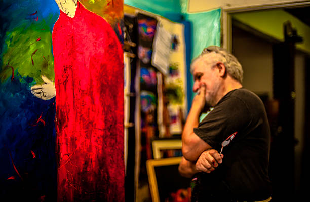 istock Elderly man with white hair, artist, painter, working.. 636916576
